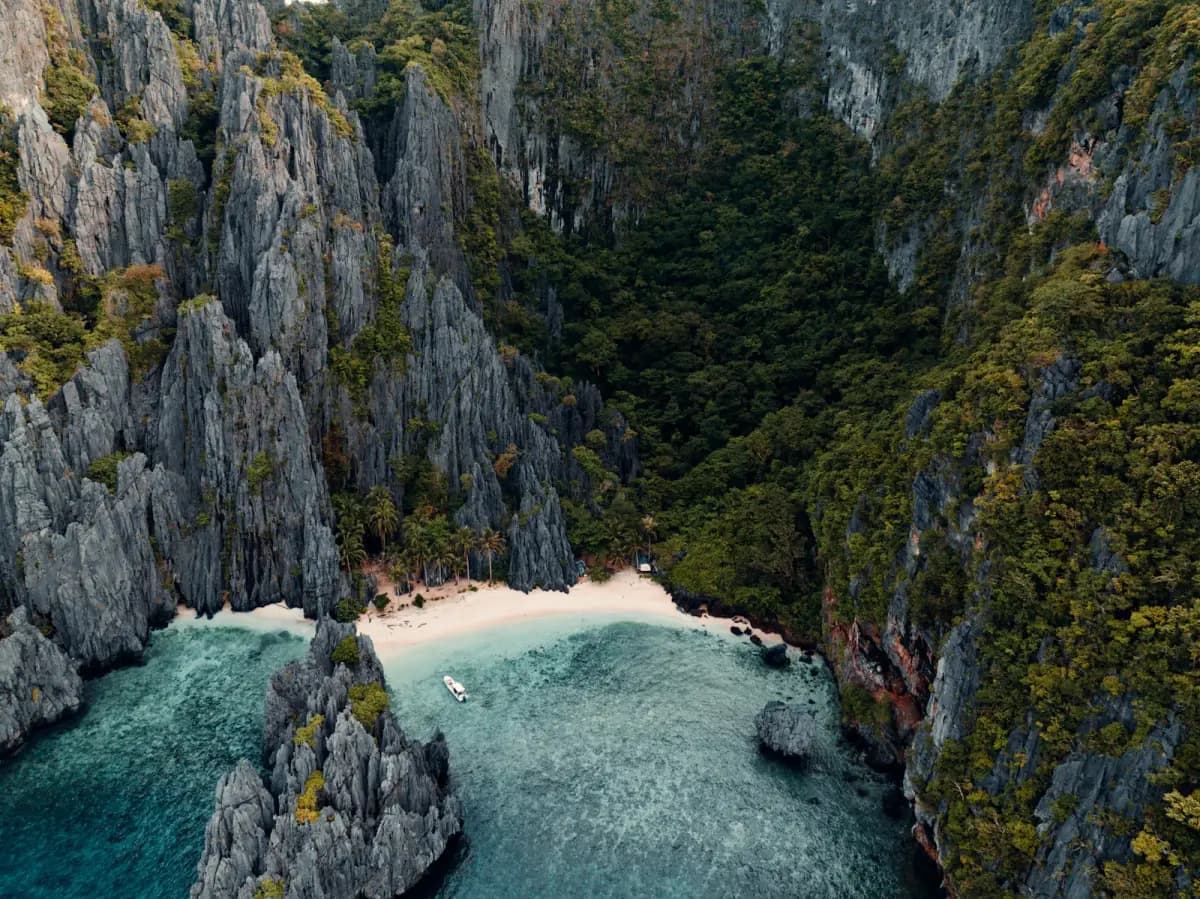 Aerial view of a white-sand beach and turquoise lagoon in El Nido, Palawan